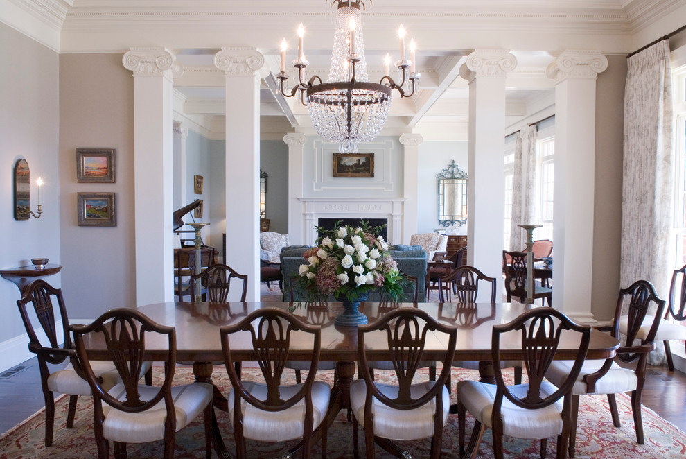 Inspiration pour une salle à manger ouverte sur le salon traditionnelle avec un mur gris et parquet foncé.