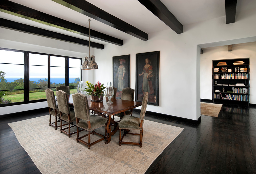 Réalisation d'une grande salle à manger méditerranéenne fermée avec un mur blanc et parquet foncé.