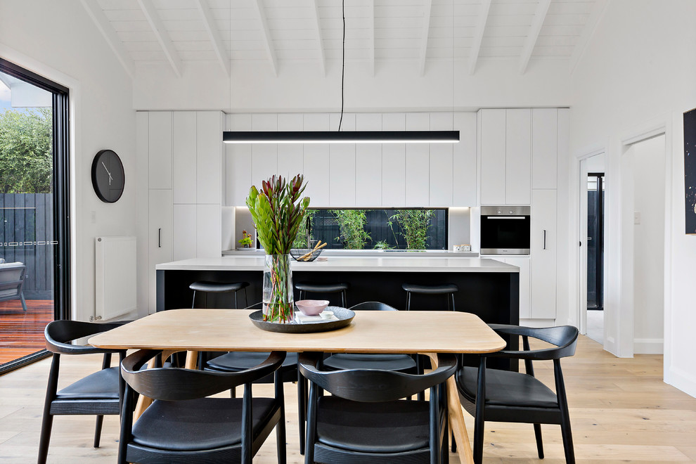 Idee per una sala da pranzo aperta verso il soggiorno contemporanea con pareti bianche, parquet chiaro e pavimento beige