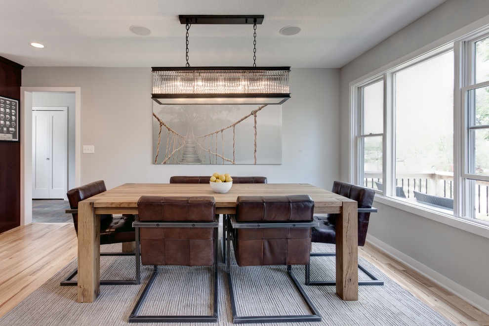 This is an example of a large contemporary open plan dining room in Minneapolis with grey walls and light hardwood flooring.