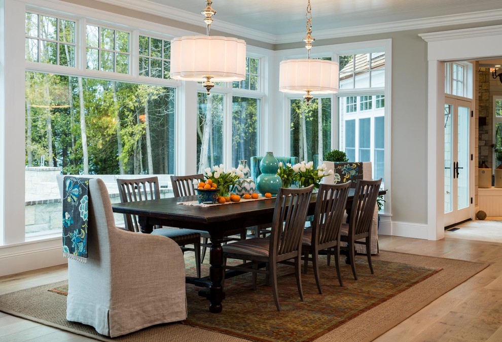This is an example of a classic dining room in Denver with grey walls, light hardwood flooring and beige floors.