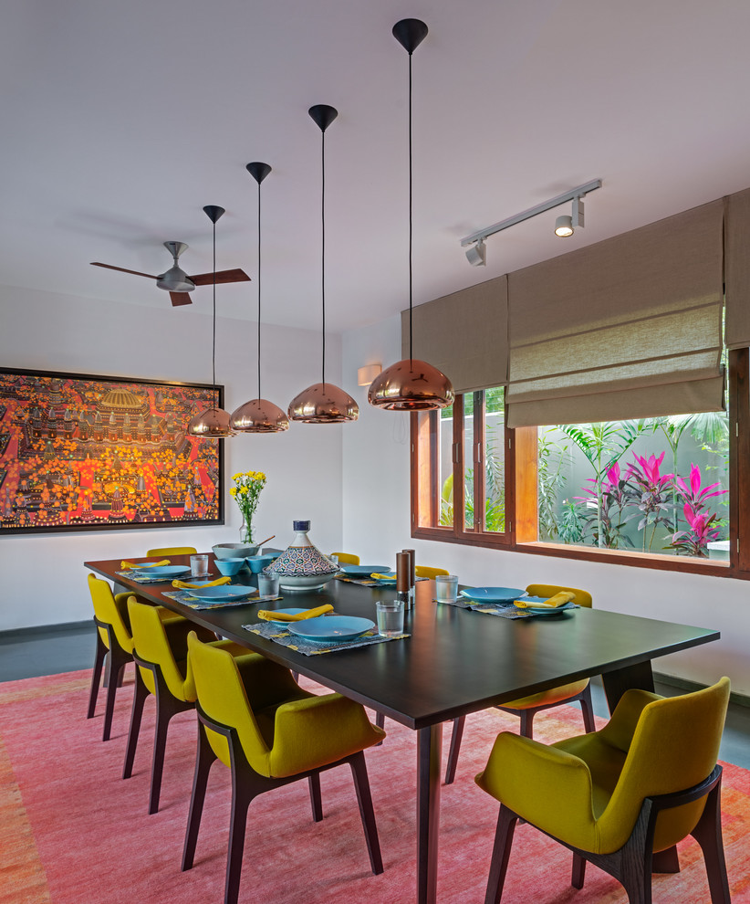 Contemporary enclosed dining room in Bengaluru with white walls and feature lighting.
