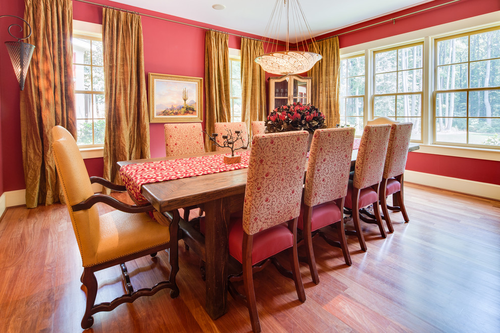 На фото: столовая в классическом стиле с красными стенами и паркетным полом среднего тона