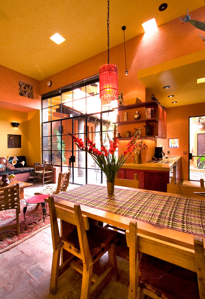 Inspiration för mellanstora eklektiska matplatser med öppen planlösning, med orange väggar och tegelgolv