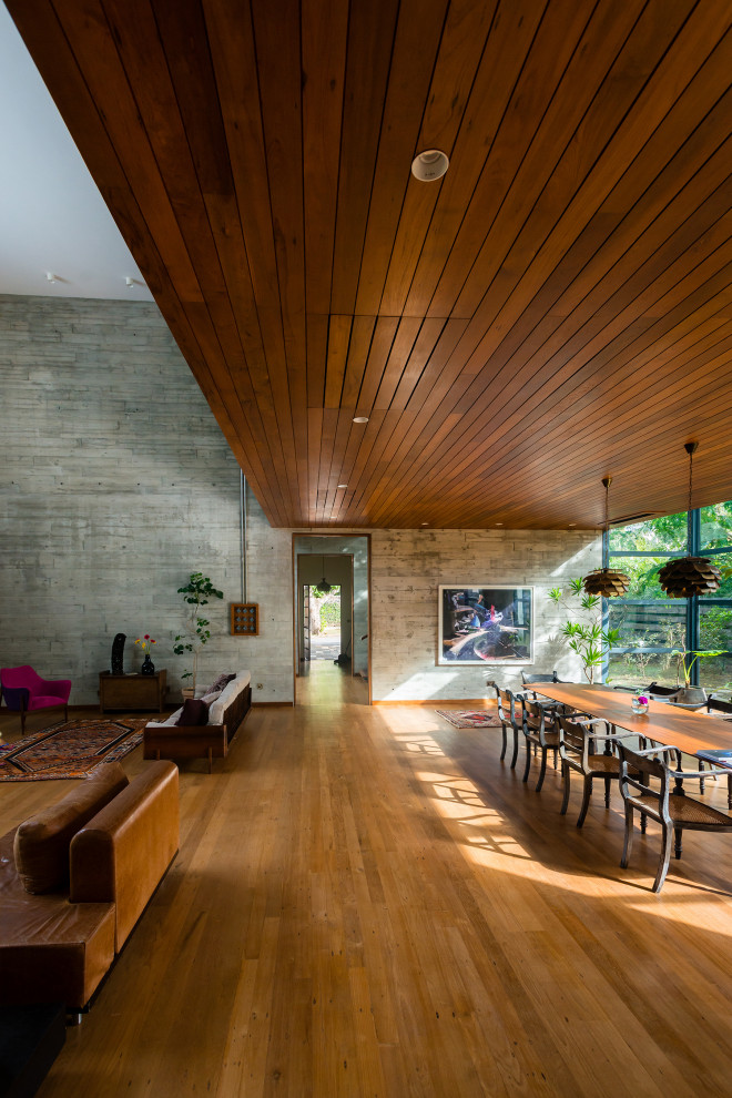 Ejemplo de comedor contemporáneo grande abierto con paredes grises, suelo de madera en tonos medios, suelo marrón y madera
