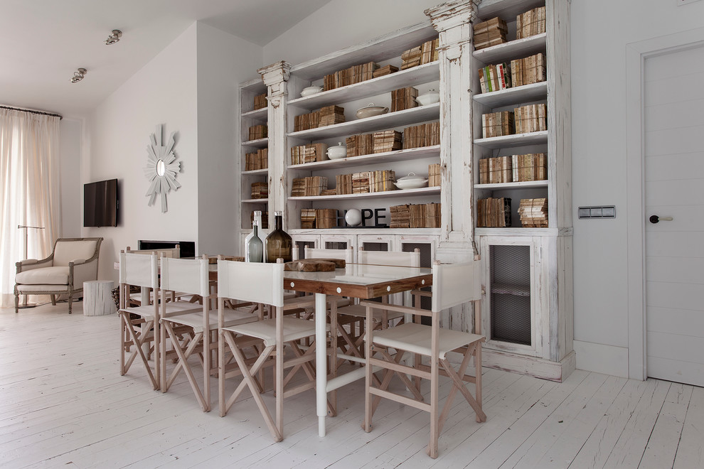 На фото: большая отдельная столовая в скандинавском стиле с белыми стенами и деревянным полом без камина