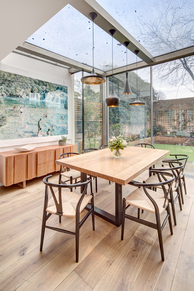 Inspiration for a contemporary medium tone wood floor dining room remodel in London with white walls