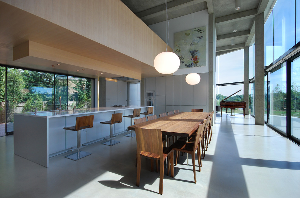 Источник вдохновения для домашнего уюта: большая гостиная-столовая в современном стиле с зелеными стенами и бетонным полом