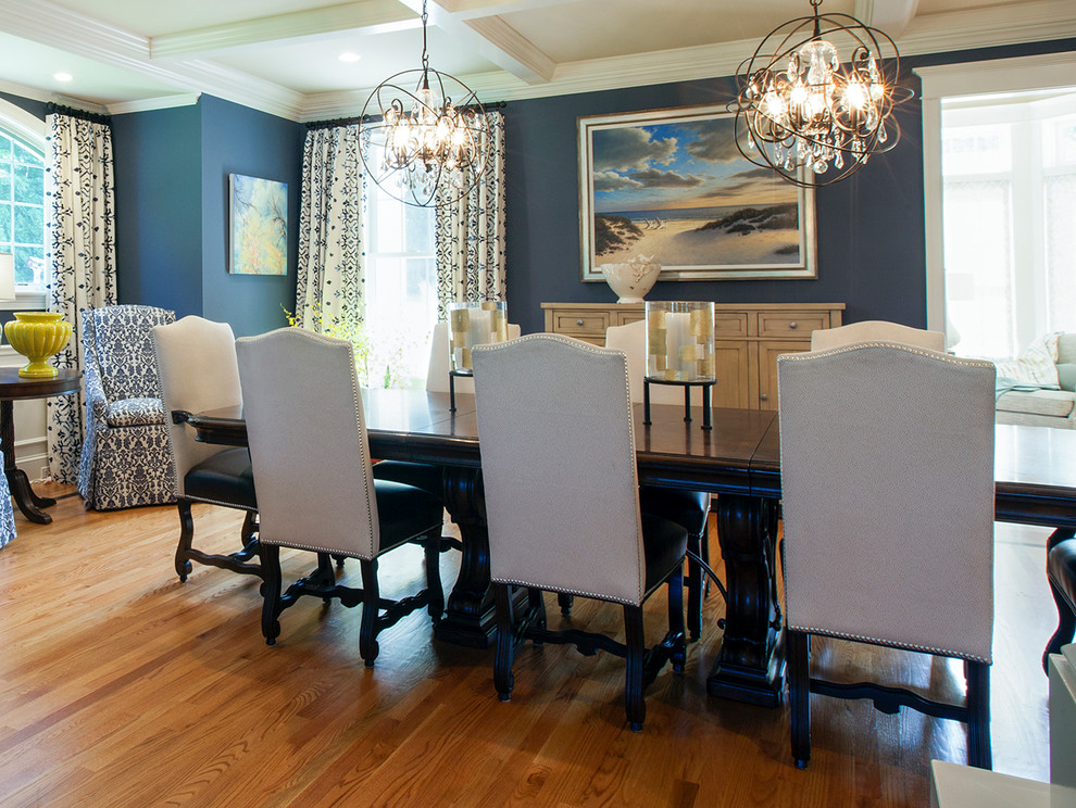 Immagine di una grande sala da pranzo classica chiusa con pareti blu, pavimento in legno massello medio e nessun camino