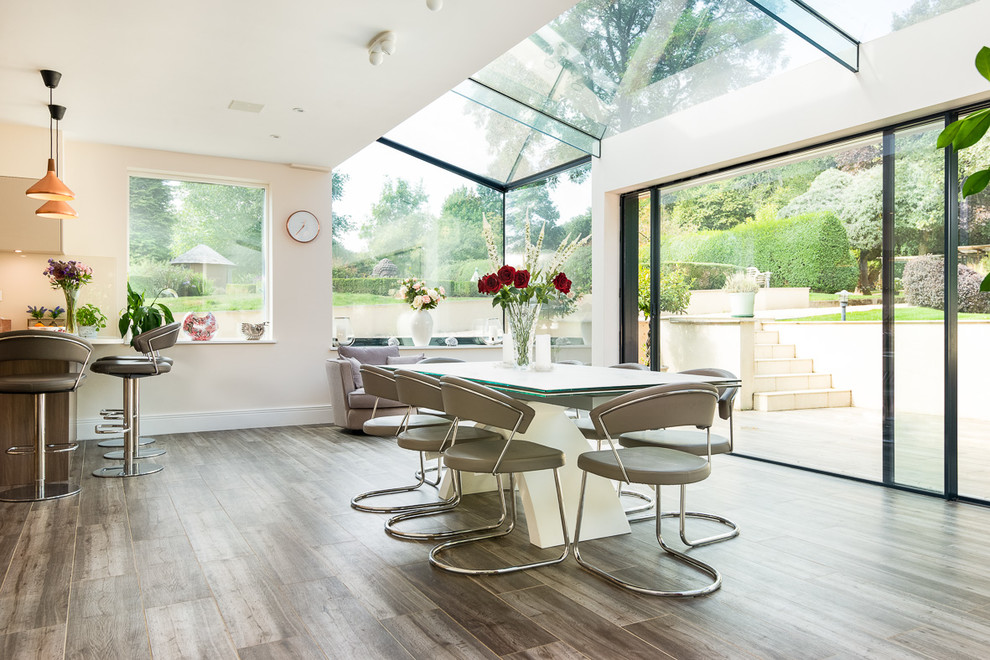 Contemporary open plan dining room in Oxfordshire with beige walls and grey floors.