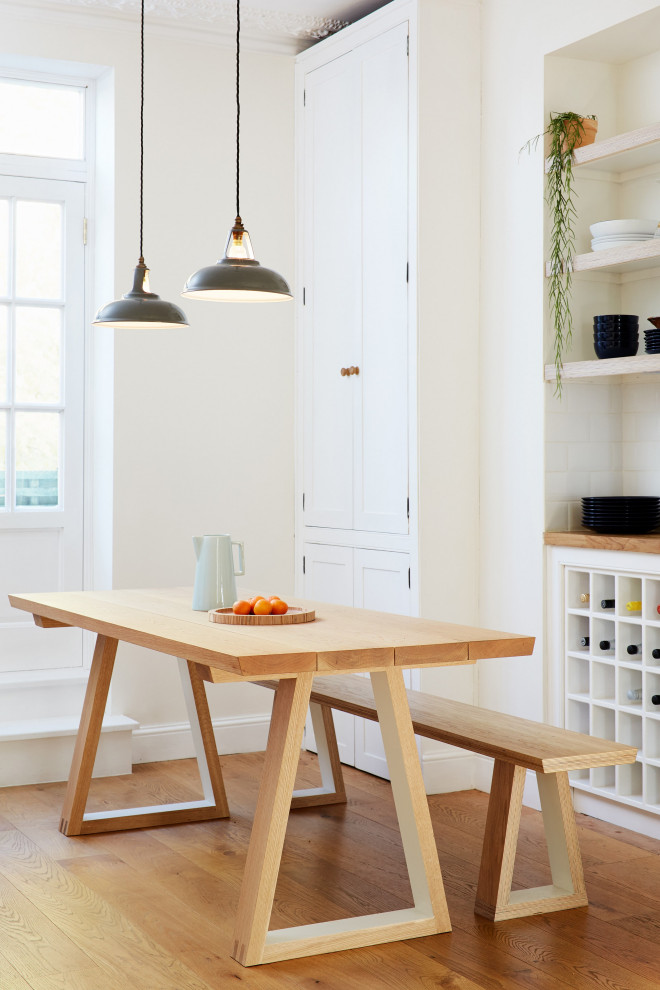Foto de comedor escandinavo de tamaño medio sin chimenea con suelo de madera en tonos medios y paredes blancas