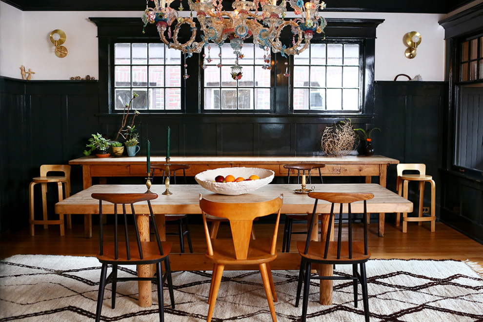 Inspiration pour une salle à manger minimaliste de taille moyenne avec un mur noir et parquet clair.