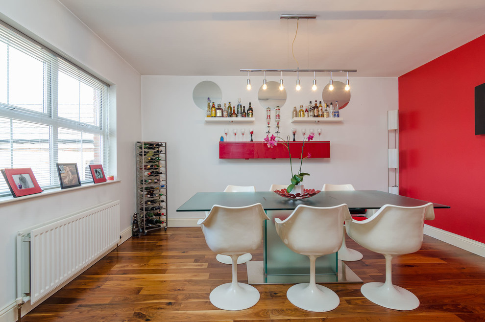 Photo of a contemporary dining room in Belfast with red walls, medium hardwood flooring and no fireplace.