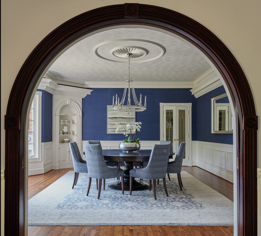 На фото: столовая в стиле неоклассика (современная классика) с синими стенами, паркетным полом среднего тона и коричневым полом