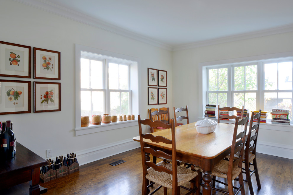 Example of a transitional medium tone wood floor enclosed dining room design in Ottawa with white walls