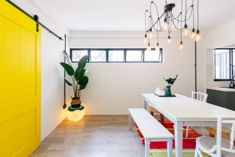 Idee per una sala da pranzo aperta verso la cucina bohémian con pareti bianche, pavimento marrone e parquet chiaro