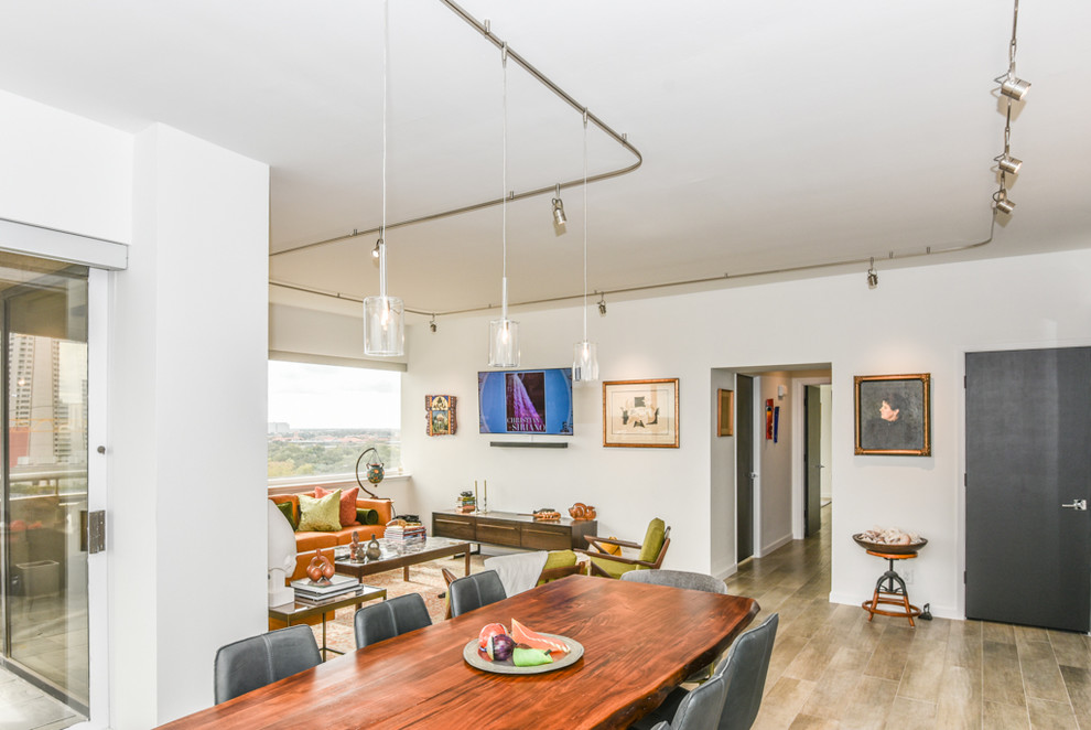 Foto di una sala da pranzo aperta verso il soggiorno minimalista con pareti bianche, pavimento in gres porcellanato e pavimento grigio