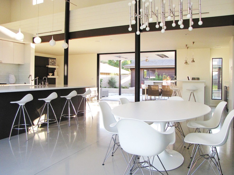 Aménagement d'une salle à manger ouverte sur le salon rétro avec un sol gris.