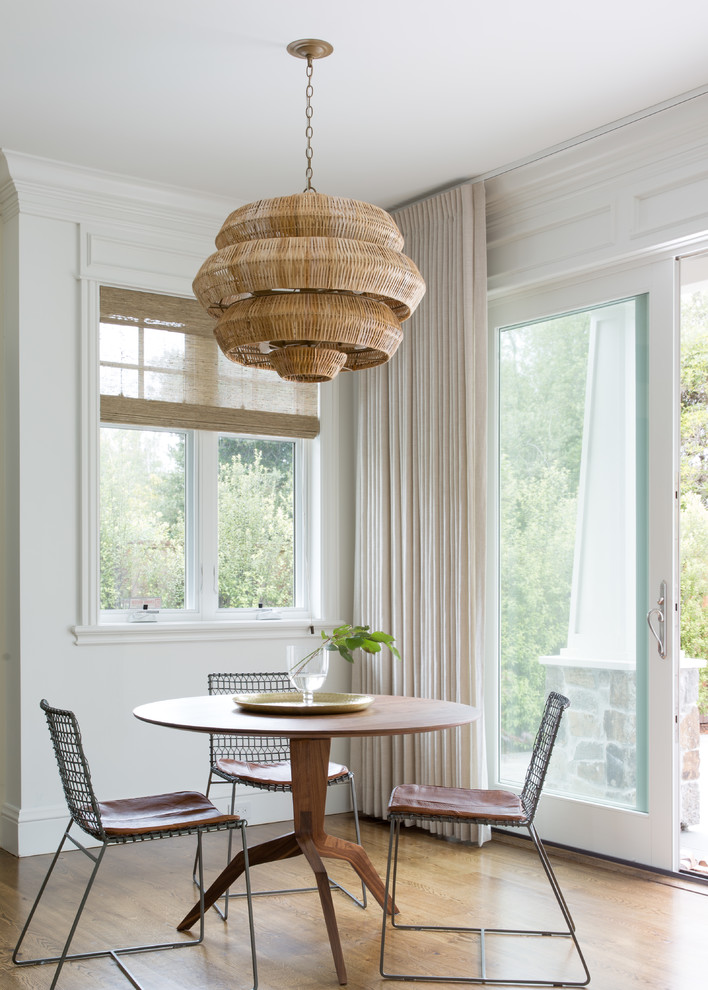 Diseño de comedor clásico renovado con paredes blancas, suelo de madera en tonos medios y suelo marrón