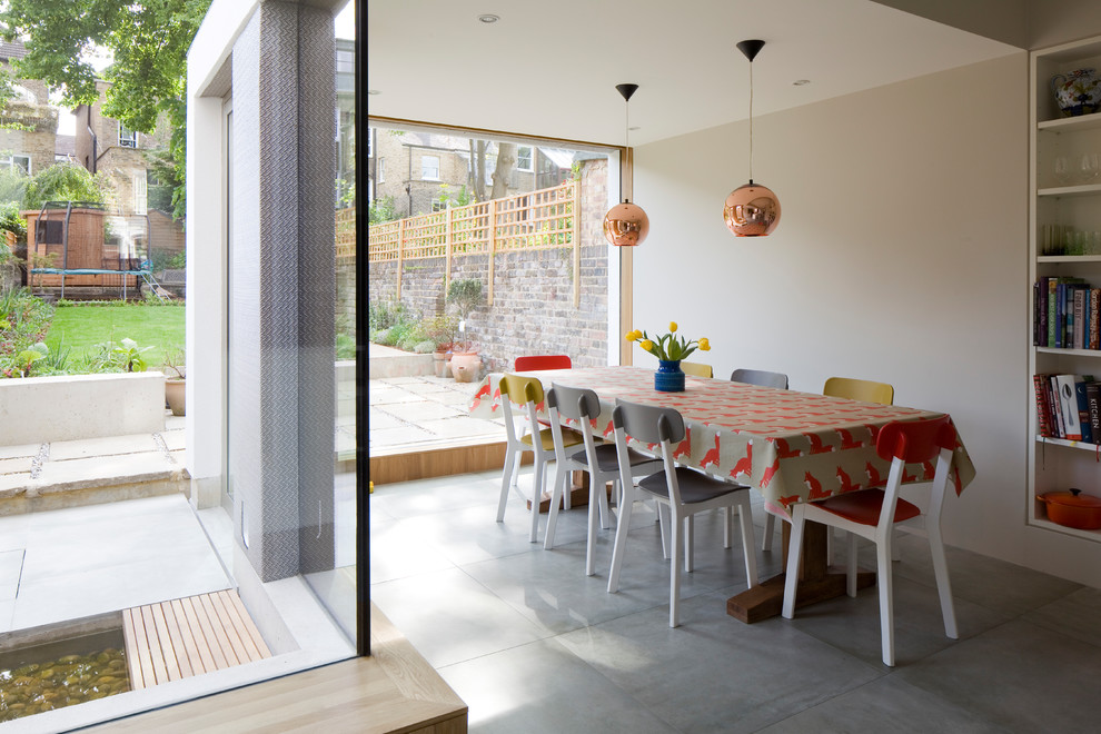 Inspiration for a medium sized contemporary enclosed dining room in London with grey floors, beige walls and concrete flooring.