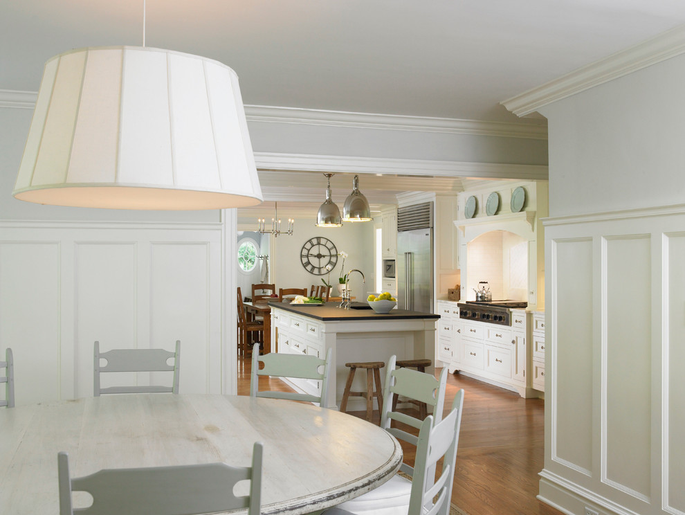 Photo of a country kitchen/dining room in New York with white walls, dark hardwood flooring and feature lighting.