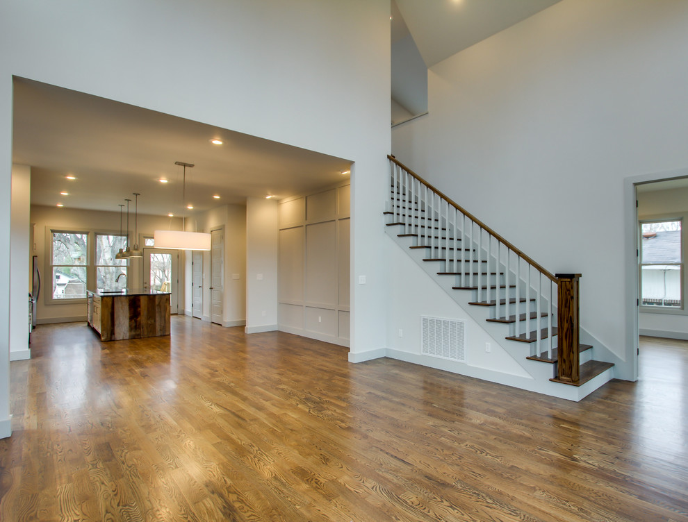 Mid-sized trendy medium tone wood floor and brown floor great room photo in Nashville with white walls