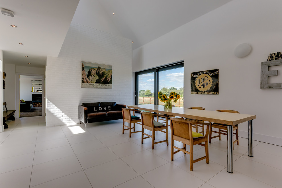 Foto di un'ampia sala da pranzo aperta verso il soggiorno contemporanea con pareti bianche