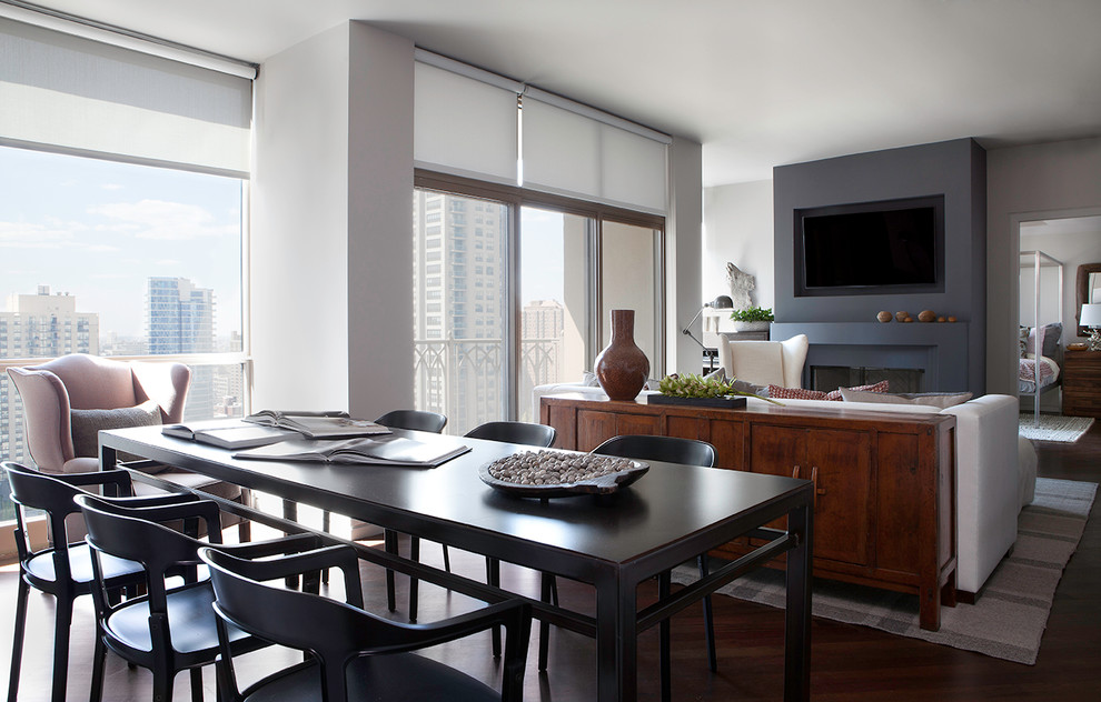 Exemple d'une salle à manger ouverte sur la cuisine chic de taille moyenne avec un mur gris, parquet foncé et une cheminée standard.