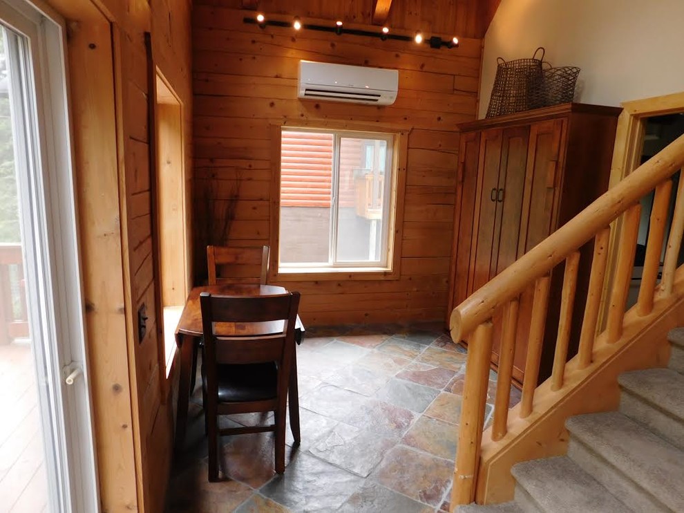 Idée de décoration pour une petite salle à manger craftsman fermée avec un mur marron, un sol en ardoise, aucune cheminée et un sol marron.
