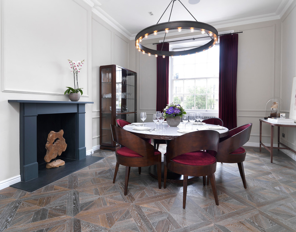 Mittelgroße Wohnküche mit weißer Wandfarbe, braunem Holzboden, Kamin und Kaminumrandung aus Stein in London
