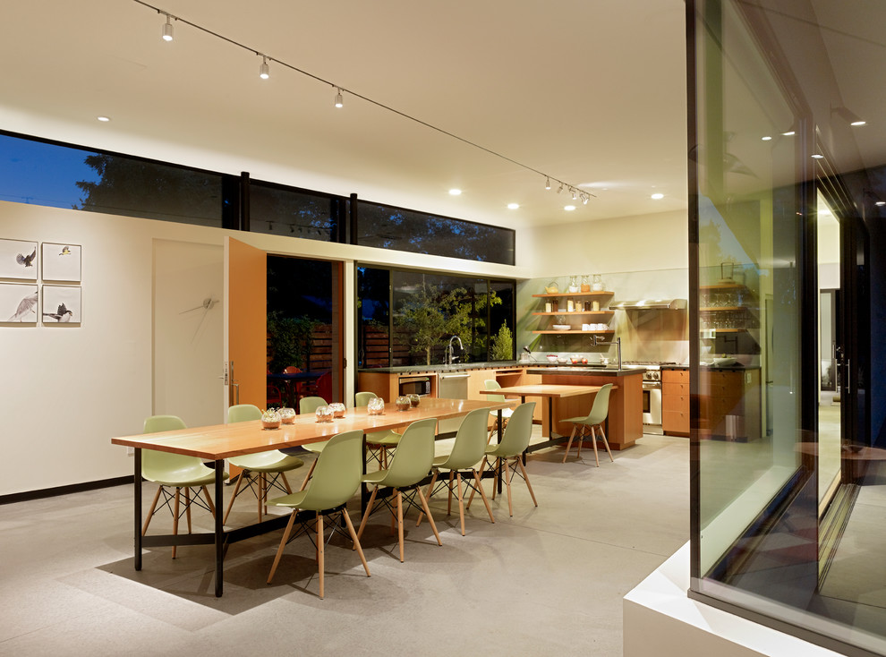 Ispirazione per una sala da pranzo minimalista con pavimento in cemento