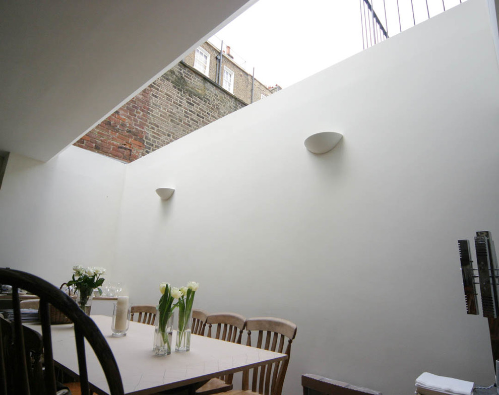 Ispirazione per una grande sala da pranzo design con pareti bianche e pavimento in legno massello medio