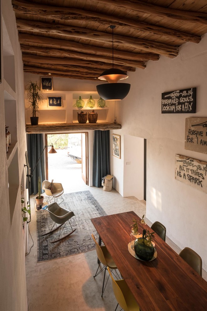 Cette image montre une salle à manger ouverte sur le salon méditerranéenne de taille moyenne avec un mur blanc, aucune cheminée et éclairage.