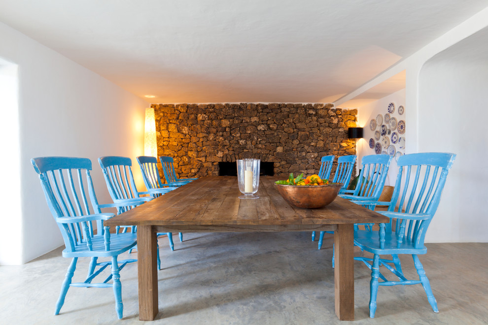 Idée de décoration pour une salle à manger méditerranéenne avec un sol gris et éclairage.