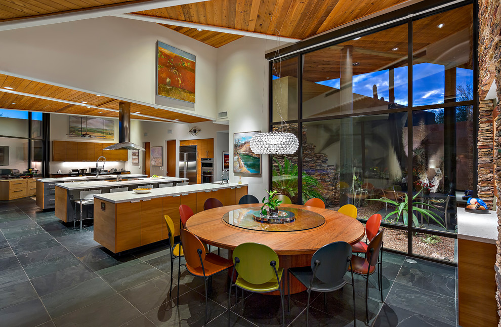 Inspiration pour une salle à manger ouverte sur la cuisine design avec un mur beige et un sol noir.