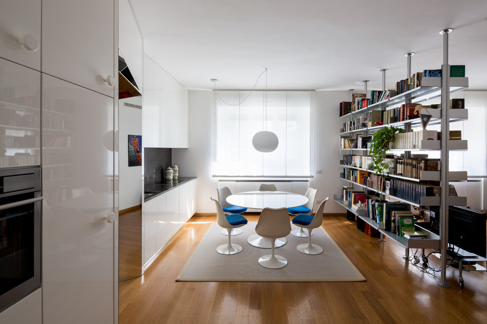 Offenes, Mittelgroßes Modernes Esszimmer ohne Kamin mit weißer Wandfarbe, hellem Holzboden und braunem Boden in Mailand