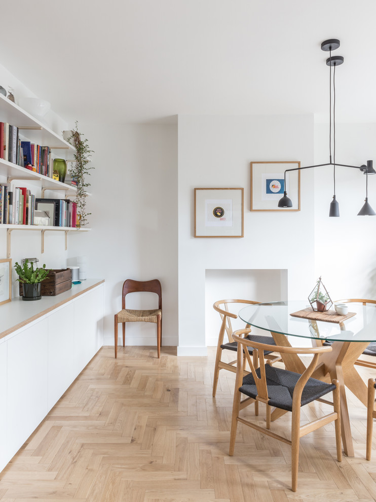 Immagine di una sala da pranzo aperta verso il soggiorno scandinava con pareti bianche, parquet chiaro e pavimento beige
