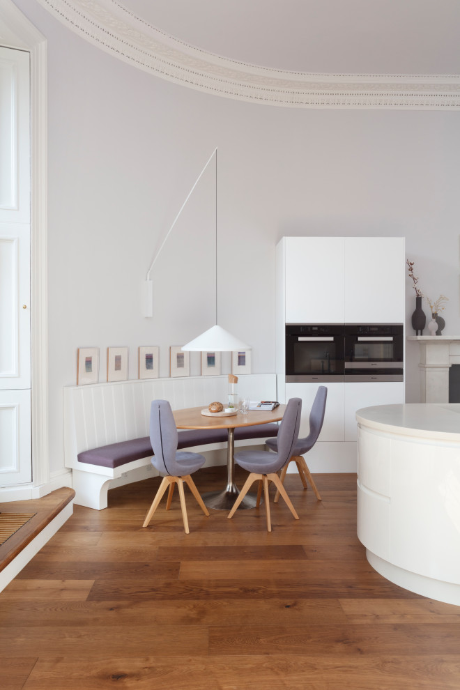 Diseño de comedor contemporáneo pequeño sin chimenea con con oficina y suelo de madera en tonos medios