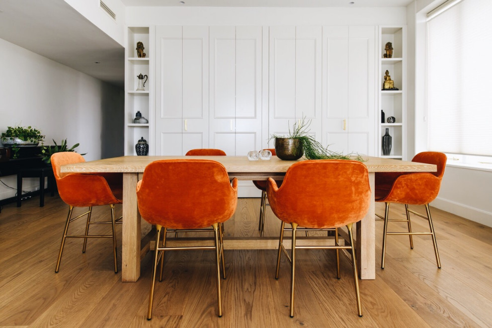 Inspiration pour une salle à manger ouverte sur le salon traditionnelle de taille moyenne avec un mur blanc, parquet clair, un sol marron et boiseries.