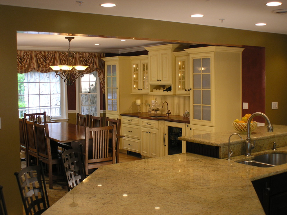Immagine di una sala da pranzo aperta verso la cucina classica di medie dimensioni con pareti rosse e parquet chiaro