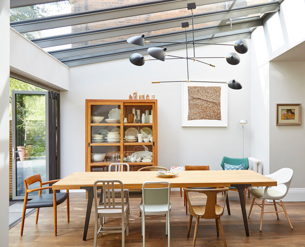 Ispirazione per una sala da pranzo aperta verso la cucina minimal di medie dimensioni con pareti bianche, parquet chiaro e nessun camino