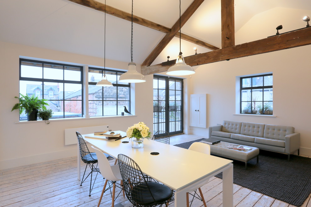 Foto di una sala da pranzo aperta verso il soggiorno minimal con pareti bianche e parquet chiaro