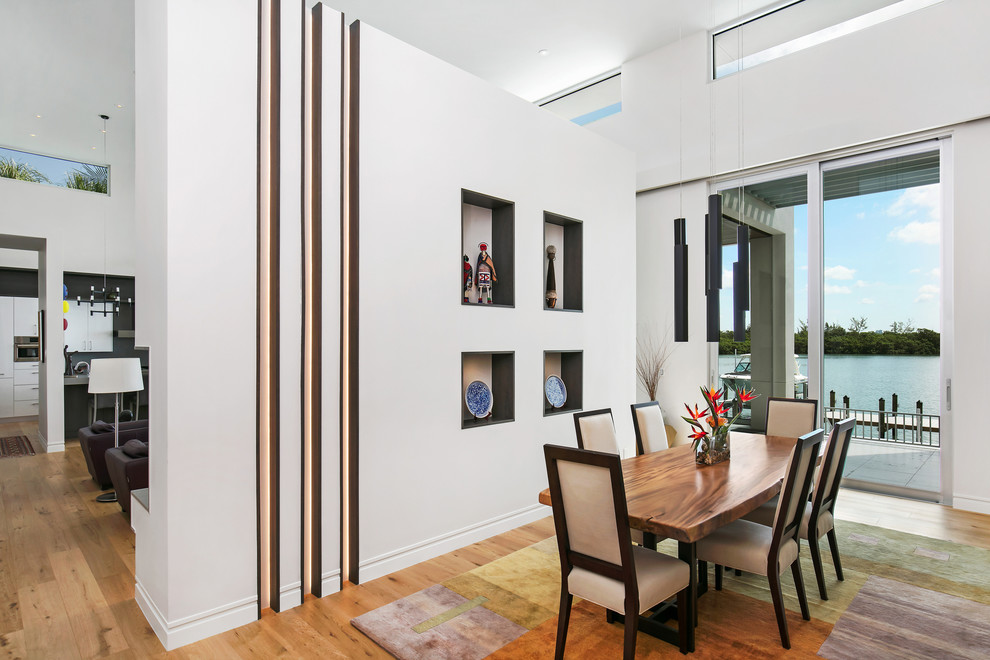 Aménagement d'une salle à manger ouverte sur le salon contemporaine de taille moyenne avec un mur blanc, parquet clair, une cheminée ribbon, un manteau de cheminée en carrelage et un sol marron.