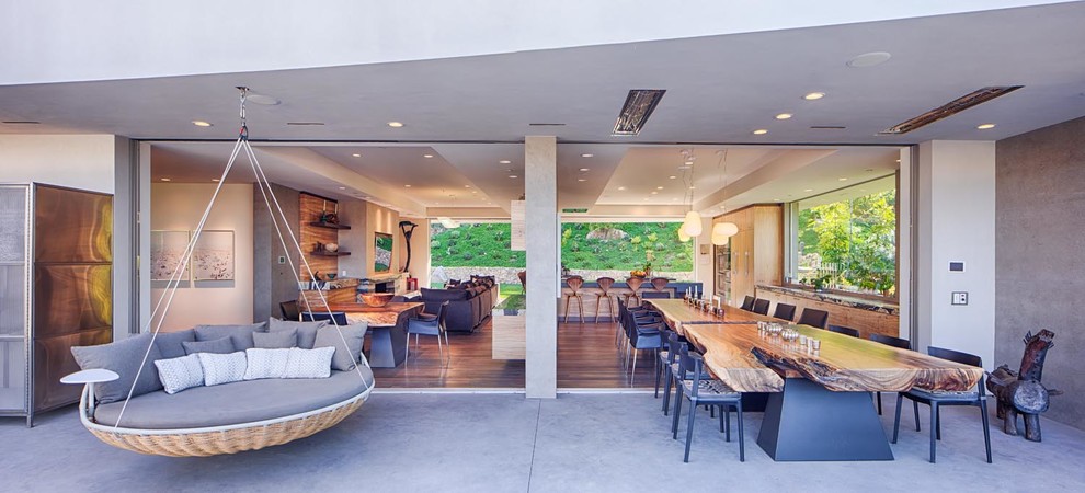 Immagine di un'ampia sala da pranzo aperta verso la cucina contemporanea con pareti grigie e parquet chiaro