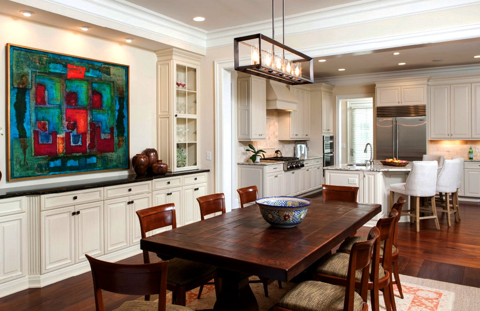 Immagine di una sala da pranzo aperta verso la cucina classica di medie dimensioni con pavimento in legno massello medio, pareti beige e nessun camino