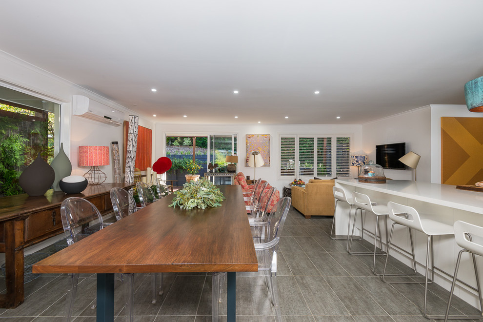 Immagine di una sala da pranzo aperta verso la cucina minimal di medie dimensioni con pareti bianche e pavimento con piastrelle in ceramica
