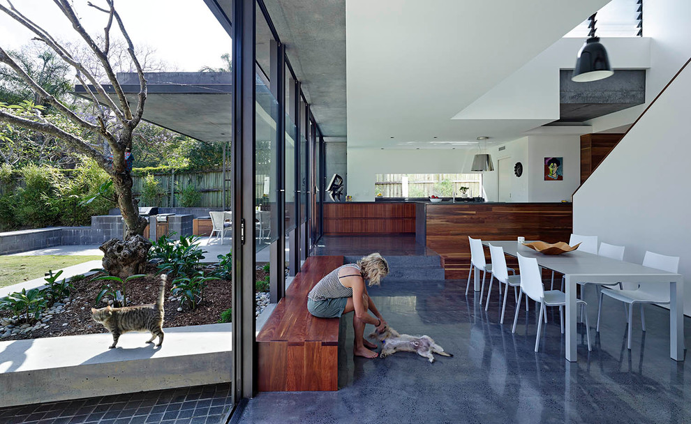 Стильный дизайн: кухня-столовая в современном стиле с белыми стенами и бетонным полом - последний тренд