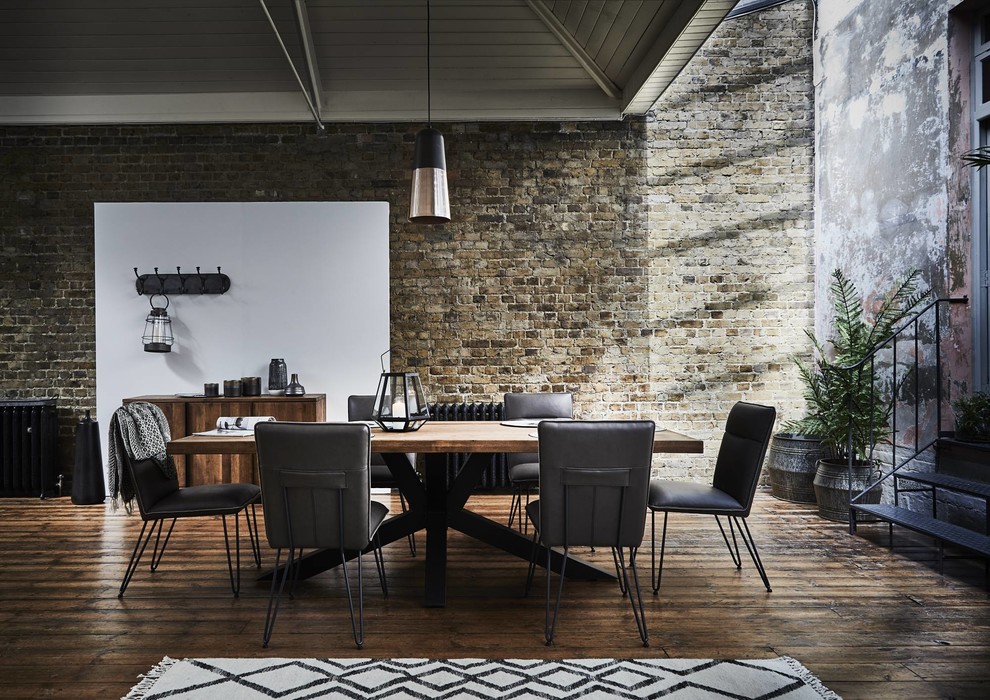 Immagine di un'ampia sala da pranzo industriale con pavimento in legno massello medio e pavimento marrone