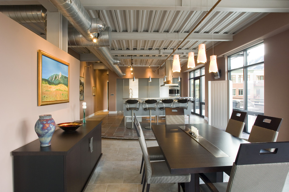 Foto di una sala da pranzo aperta verso il soggiorno industriale di medie dimensioni con pareti beige, pavimento con piastrelle in ceramica, nessun camino e pavimento grigio