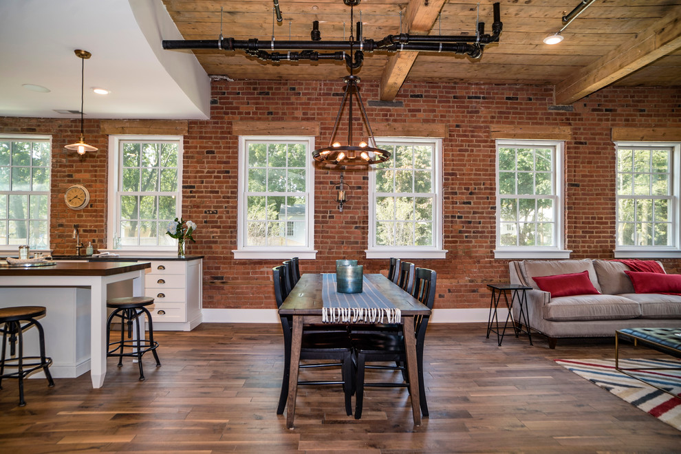Idee per una sala da pranzo aperta verso il soggiorno industriale con pavimento in legno massello medio